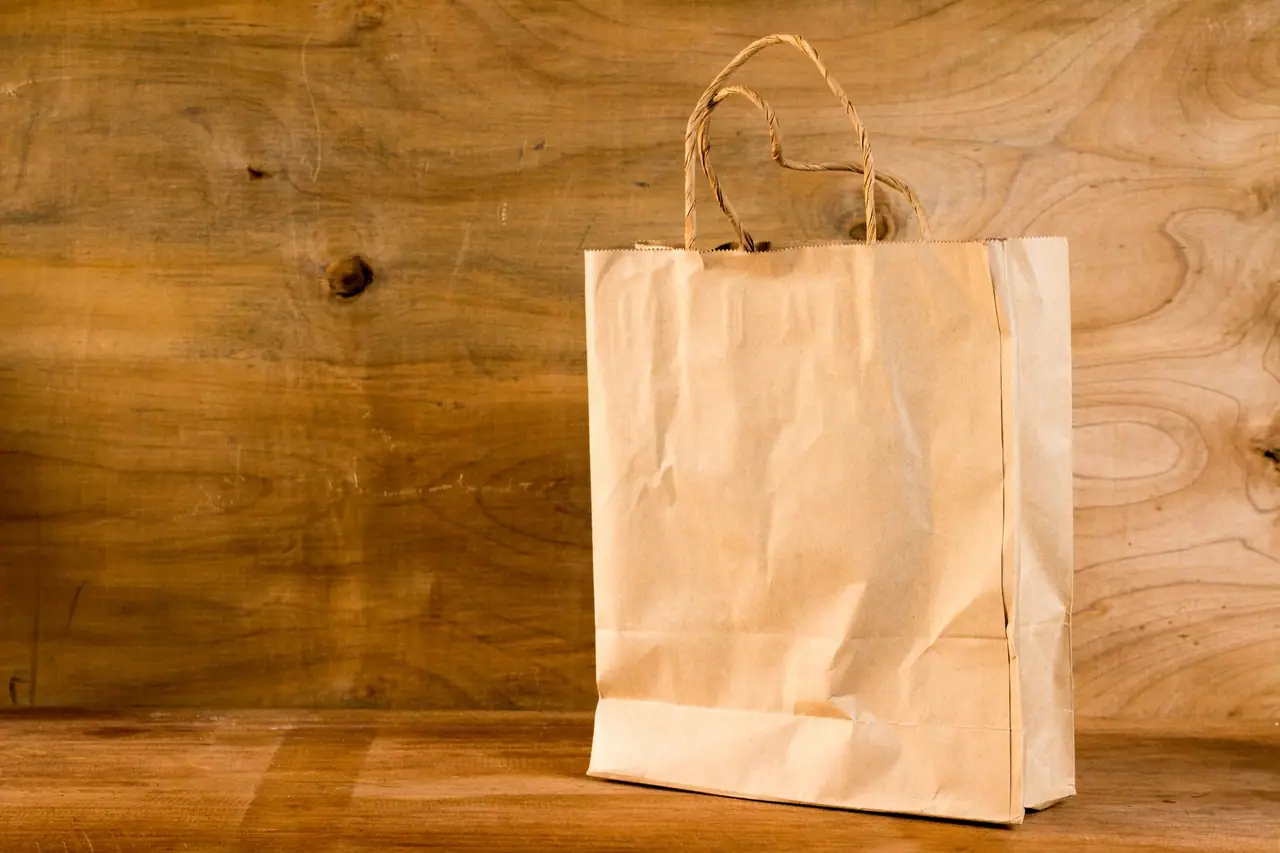 Kraft paper bag with twisted handles on a wooden table
