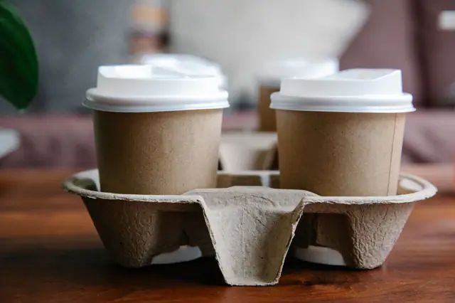 Two kraft paper coffee cups in a cup carrier