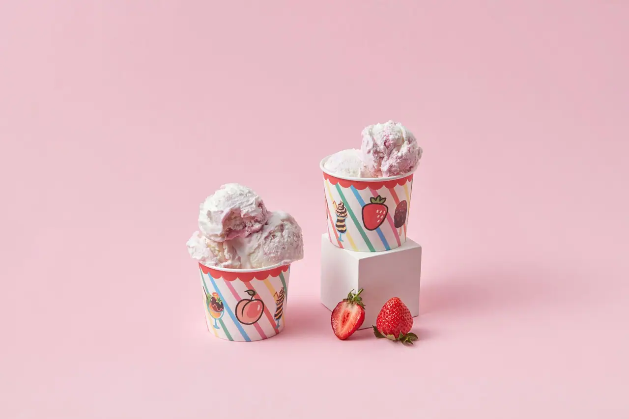 Ice cream in paper cups with strawberries
